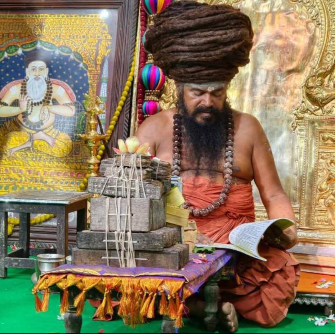 Guruji B.S. Vignesh Swamy reading a palm-leaf Nadi manuscript