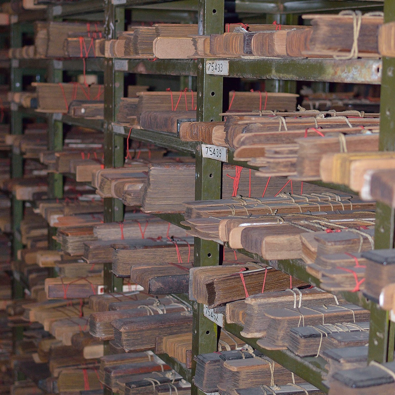Shelves of catalogued palm-leaf manuscript bundles in an archive